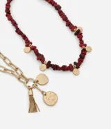Collar doble en capas con baño en tono dorado. Una de las piezas presenta piedras irregulares en color bordó con pequeñas medallas circulares, mientras que la otra consiste en una cadena de eslabones alargados con un dije de borla y medallas texturizadas.