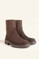 Bota tipo chelsea de gamuza color marrón, con paneles laterales elásticos acanalados y suela de goma track con taco bajo.