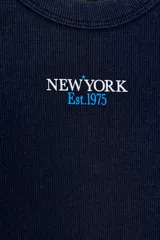 Musculosa de corte ajustado confeccionada en tejido rib de mezcla de algodón. Presenta escote redondo, diseño sin mangas y detalle de texto estampado a contraste en el frente.