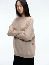 Sweater tejido de color marrón oscuro, con cuello a la base, mangas largas y silueta holgada de calce relajado.