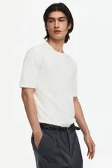 Remera de punto fino color blanco, con cuello redondo acanalado y mangas cortas, de corte slim fit.