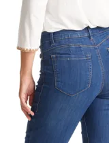 Jean de tiro alto con corte bootcut, ajustado en cadera y muslos con una sutil apertura desde la rodilla. Presenta diseño clásico de cinco bolsillos, cierre con botón y costuras en contraste. Su diseño posterior incluye costuras estratégicas para un efecto de realce en la silueta.