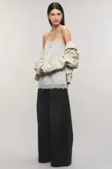 Top negro de satén jacquard, con escote en V de estilo lencero decorado con puntilla delicada al igual que el ruedo, breteles finos regulables y aberturas laterales.