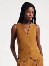 Chaleco sastrero de lino color marrón, con escote en V, cierre frontal con botones y bolsillos laterales simulados.