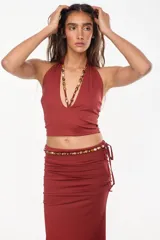 Top halter color bordó con escote profundo y tirantes decorados con cuentas artesanales.