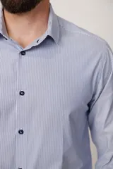 Camisa de vestir a rayas verticales azules y blancas, de corte entallado, con cuello clásico y puños abotonados.
