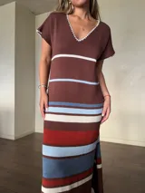 Vestido largo de tejido de punto de algodón, con diseño rayado en tonos marrón, celeste, blanco y rojo. Presenta escote en V con detalle de costura en contraste, mangas cortas, silueta holgada y aberturas laterales en el dobladillo.