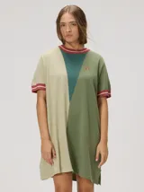 Vestido corto de punto con diseño en bloques de color verde militar, beige y verde oscuro. Presenta cuello redondo y puños en las mangas cortas con rayas rojas y beige, además de un pequeño bordado en el pecho.