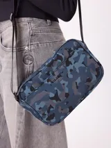 Bolso tipo morral de la marca Rusty, con diseño estampado camuflado en tonos marrones. Cuenta con correa ajustable y cierre frontal con logo de la marca.