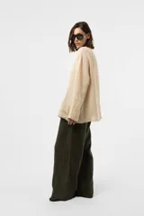 Pantalon de lino verde militar, de calce relajado y pierna amplia, con cintura elastizada, boton delantero y pinzas en el frente.