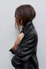 Blazer de cuero sintético negro con solapas clásicas, cierre de un botón y bolsillos frontales con solapa.