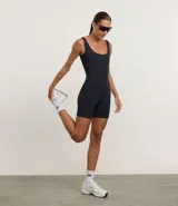 Enterito deportivo corto de microfibra color marrón, con escote redondeado, breteles anchos y bolsillos laterales funcionales.