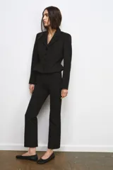 Blazer corta negra de la colección Zara Woman, con cuello solapa de muescas y manga larga. Presenta detalles de pespuntes marcados y forro interior a tono. Cierre frontal con botones.