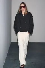 Trench corto negro confeccionado en hilatura con mezcla de algodón. Cuello solapa de muescas ajustable con trabilla y botones. Manga larga. Bolsillos delanteros. Detalle de trabillas en hombros. Cierre frontal cruzado con botones.