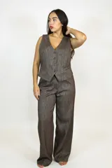 Chaleco de corte sastrero en color marrón con textura jaspeada, presenta escote en V, cierre frontal con botones y bolsillos laterales decorativos.