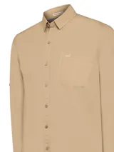 Camisa de manga larga RKF modelo Galiton, color beige, con cuello camisero, cierre frontal de botones y bolsillo en el pecho con logo bordado. Presenta botones en los laterales de las mangas para ajuste y está confeccionada en popelina de algodón orgánico con protección UV.