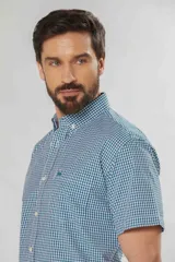 Camisa de manga corta a cuadros vichy en tonos verde y blanco, con cuello abotonado y bolsillo frontal.