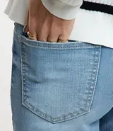 Pantalón de jean celeste, de corte recto cropped, con trabillas en la cintura, bolsillos y cierre por botón y cremallera.