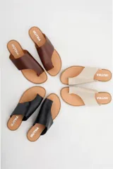 Sandalias chatas de cuero color crudo, con diseño geométrico y minimalista.