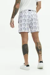 Short de baño con estampado geométrico en tonos azul y rosado, con cintura elástica y cordón de ajuste. Cuenta con bolsillos laterales y un bolsillo trasero.