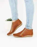 Zapato bajo de cuero negro con puntera redondeada y cierre frontal con cremallera doble.