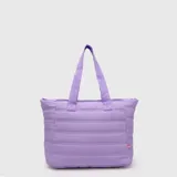 Tote bag acolchada de color azul marino, con diseño de costuras horizontales, doble asa superior y bolsillo frontal con cierre. Incluye compartimento interno para laptop.