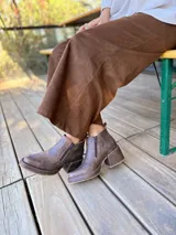 Botas cortas de cuero con efecto desgastado en color chocolate, con taco cuadrado y plataforma. Presentan cierre lateral y punta redondeada.