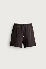 Bermuda estilo jogger de ajuste relajado, confeccionada en tejido interlock de algodón. Cuenta con cintura elástica ajustable con cordón, bolsillos frontales de vivo y diseño liso.