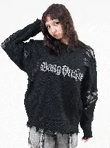 Buzo de punto negro con diseño de estilo desgastado y roturas en mangas y ruedo. Presenta una estampa frontal con tipografía gótica en color gris.