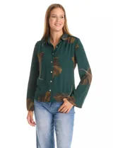 Camisa de crepe con estampado floral en tonos verdes y marrones, cuello con solapa, cierre frontal con botones y detalle de mostacillas bordadas en los hombros. Presenta mangas largas con terminación amplia.
