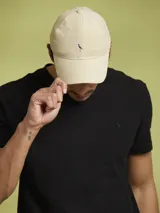 Gorro con visera color beige, confeccionado en algodón, con logo bordado en el frente.