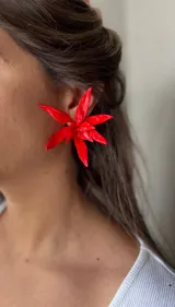 Par de aros con forma de flor de pétalos puntiagudos, hechos a mano en porcelana color rojo brillante.