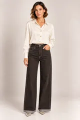 Jeans de corte ancho en color negro con pespuntes en contraste y botamangas con vuelta.