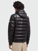 Campera puffer corta con capucha Moncler Gliere, color negro, con cierre frontal de botones a presión y bolsillos laterales con cierre. Diseño acolchado horizontal.