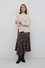 Falda midi de corte irregular con diseño a cuadros en tonos marrones, negros y beige. Presenta una silueta acampanada con caída fluida.