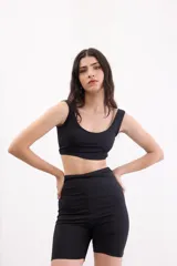 Top deportivo de lycra color negro, con escote redondo y breteles anchos, de corte ajustado al cuerpo.