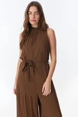Mono marrón sin mangas, con cuello alto fruncido y lazo en la cintura.
