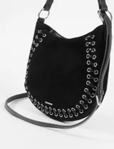 Cartera de hombro negra de gamuza con detalle de cordones entrelazados y ojales metálicos plateados en el borde. Tiene una correa de hombro y una correa larga extraíble para llevar cruzada.