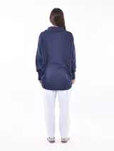 Sweater azul oscuro con cuello drapeado y corte asimétrico.