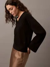 Sweater negro de punto de algodón con escote en V, puños, cuello y dobladillo con punto canalé.