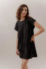 Vestido corto negro con diseño tejido en bloques, de mangas cortas y corte recto.