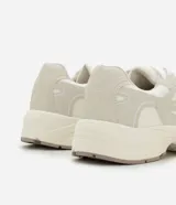 Championes deportivos de estilo urbano con capellada de material sintético, diseño con recortes y apliques superpuestos. Cuenta con cierre de cordones, entresuela robusta y suela de goma con base tractorada.