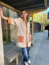 Camisa color beige con detalles en cuero color marrón en cuello, mangas y bolsillos.