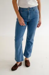 Jean de corte recto y tiro medio, confeccionado en denim azul clásico. Presenta diseño de cinco bolsillos con costuras reforzadas y cierre frontal con botón metálico.