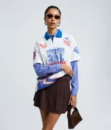 Short pollera de estilo sastre con patrón de rayas finas, diseño estructurado con pliegues delanteros y hebilla lateral ajustable.