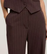 Pantalón de vestir de corte recto, color marrón oscuro con finas rayas verticales en tono más claro. Presenta un calce sastrero y bolsillos laterales.