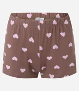 Pijama corto de dos piezas compuesto por una remera de manga corta con cuello redondo y bolsillo frontal, y un short de cintura elastizada. Ambos presentan un diseño estampado de corazones sobre fondo marrón.