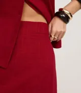 Minifalda roja de viscosa y lino, corte recto, con detalle de bolsillo falso en la parte delantera.