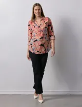 Blusa de gasa estampada con flores, marca Zac & Rachel. Tiene cuello a la base, escote en V y abertura con botones. Las mangas largas son de largo regulable.