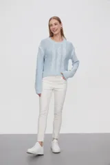 Sweater de punto color celeste, con diseño de trenzas frontales, cuello redondo y corte holgado.
